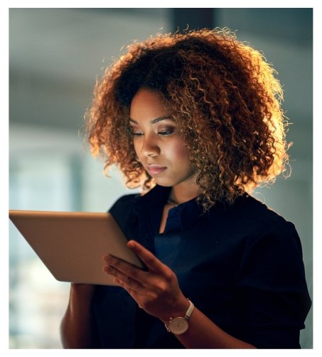 Profissional de marketing digital mexendo em um tablet desenvolvendo estratégias para o crescimento das KPIs e principais métricas.